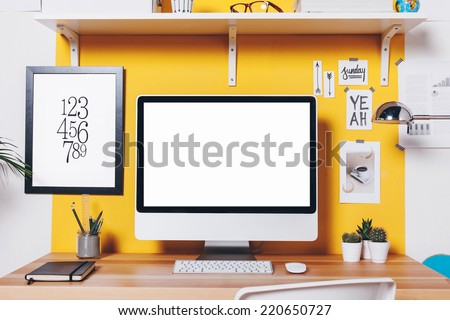 Office workplace with computer./ Modern creative workspace on yellow wall.  Royalty-Free Stock Photo #220650727
