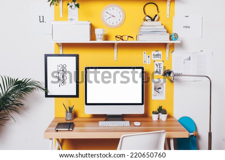 Office workplace with computer./ Modern creative workspace on yellow wall.  Royalty-Free Stock Photo #220650760