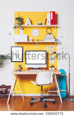 Office workplace with computer./ Modern creative workspace on yellow wall.  Royalty-Free Stock Photo #220650772
