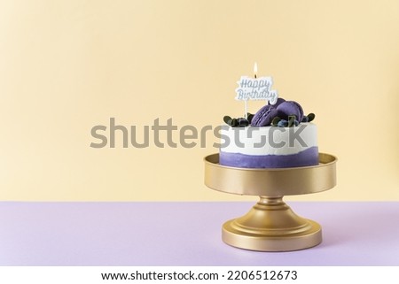 Birthday cake with candle Happy birthday decorated with macarons and berries on bright background. Horizontal, copy space. Business greeting card design, confectionery, bakery. Homemade birthday cake.