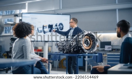 Group of Young Scientists Working: Inspecting Engine in Factory Meeting Room. People Brainstorming with Chief Engineer. Confident Industrial Specialists in Technological Facility. Royalty-Free Stock Photo #2206514469