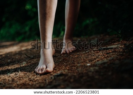 Close-up of barefoot legs walking in nature. Concept of healthy feet. Royalty-Free Stock Photo #2206523801
