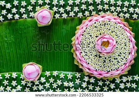 Pink lotus petal krathong decorates with its flower, crown flower for Thailand Full moon or Loy Krathong festival on banana leaves background.