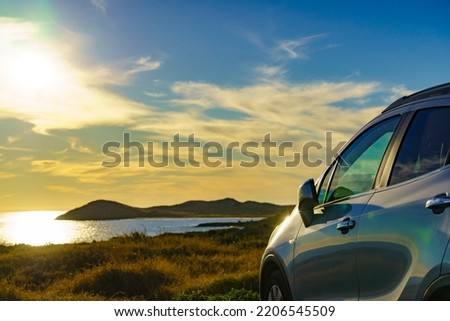 Auto parking on seashore in sunset time. Rear view mirror closed for safety at car park. Royalty-Free Stock Photo #2206545509