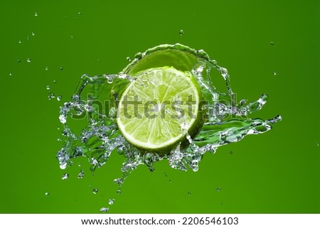 Fresh lime with water splash on green background