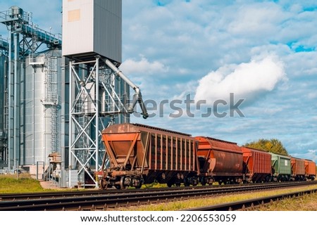 Loading railway carriages with grain at grain elevator. Grain silo, warehouse or depository is an important part of harvesting Royalty-Free Stock Photo #2206553059