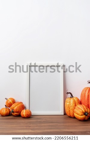 Photo frame and white pumpkins. Mockup Copy space for artwork. Autumn decor in interior.