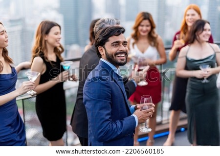 Photo of a group of businessmen and businesswomen mingle with each other drinking wine and champagne on a rooftop bar celebrating the successful of company latest deal and hit target goal of the year Royalty-Free Stock Photo #2206560185