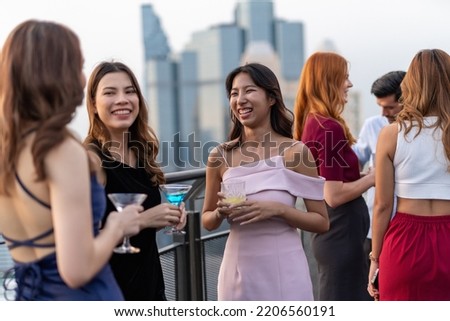 Photo of a group of young elegant businesswomen mingle with each other drinking wine and champagne on a rooftop bar celebrating the successful of company latest deal and hit target goal of the year Royalty-Free Stock Photo #2206560191