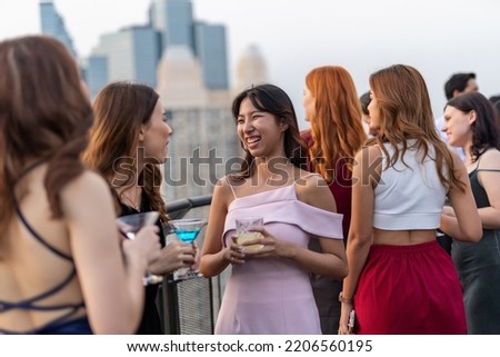 Photo of a group of young elegant businesswomen mingle with each other drinking wine and champagne on a rooftop bar celebrating the successful of company latest deal and hit target goal of the year Royalty-Free Stock Photo #2206560195