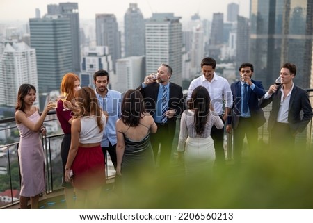 Photo of a group of businessmen and businesswomen mingle with each other drinking wine and champagne on a rooftop bar celebrating the successful of company latest deal and hit target goal of the year Royalty-Free Stock Photo #2206560213