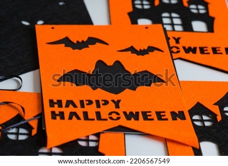 Festive Halloween decor in the form of black and orange flags with symbols, preparation for the holiday. Holidays, decoration and party concept