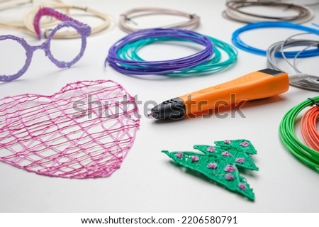 3d Pen. Printing with Colored Plastic Wire Filament. Child making a Christmas Three, Heart shape drawing with 3D pen. Artwork, Robotics. STEAM, STEM education. Modern Technologies. Study at home Royalty-Free Stock Photo #2206580791