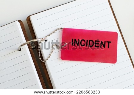 A red card with the text INCIDENT against the background of an open notepad on the table