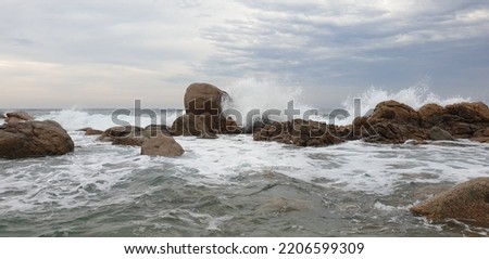 Waves crashing against rocky shoreline Royalty-Free Stock Photo #2206599309