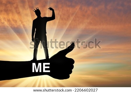Selfishness and narcissism. A selfish man with a crown on his head points his finger at himself. The concept of egoism and narcissism. Social problems. Silhouette Royalty-Free Stock Photo #2206602027