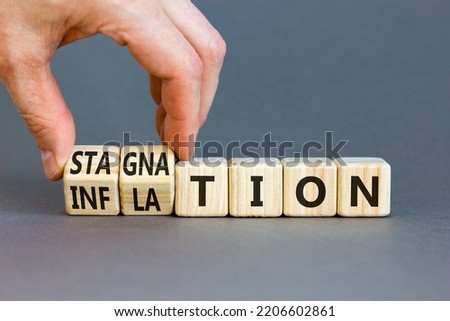 Inflation and stagnation symbol. Businessman turns cubes, changes the word inflation to stagnation. Beautiful grey table, grey background, copy space. Business, inflation and stagnation concept. Royalty-Free Stock Photo #2206602861