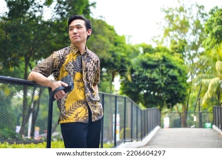 Asian Man Wearing Batik Pattern Indonesia Shirt Smiling Royalty-Free Stock Photo #2206604297