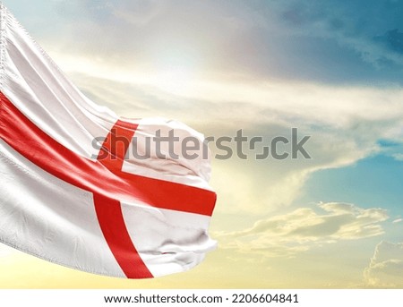 England national flag waving in beautiful sky.