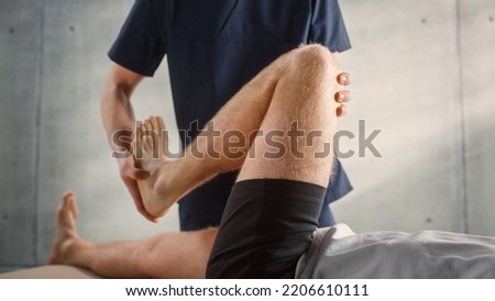 Close Up of a Young Male Athlete Undergoing Physiotherapy, Professional Sport Masseur Treating Light Muscle or Joint Injury. Musculoskeletal Pain Therapy and Rehabilitation In Modern Clinic Concept. Royalty-Free Stock Photo #2206610111