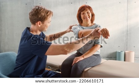 Advanced Sport Physiotherapy Specialist Stretching and Working on Specific Muscles or Shoulder Joints with Fit Elderly Woman. MIddle Aged Female Recovering from Mild Injury, Undergoing Rehabilitation.