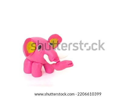 Cute elephant plasticine sculpture, pink body on white background. Handmade clay plasticine