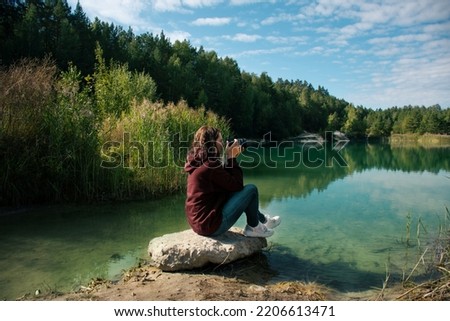 beautiful view of the lake in the forest among the firs on a clear summer bright warm day.