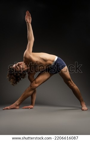 Slim woman doing handstand in studio