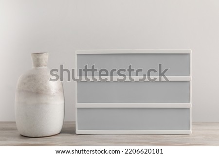 Blank letter board and vase on wooden table. Mockup for design