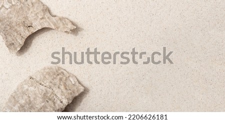 Natural cosmetic background for product presentation. Beige rocks on the sand. Top view.
