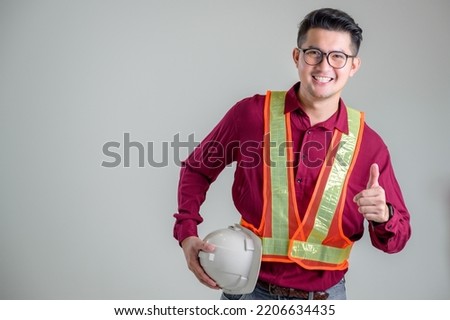 Asian male engineer or architect with a white helmet on a white background standing in a photo studio. Asian workers work on building projects. happy smiling worker