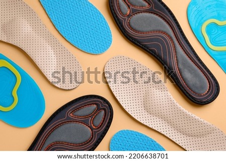 Many different shoe insoles on pale orange background, flat lay Royalty-Free Stock Photo #2206638701