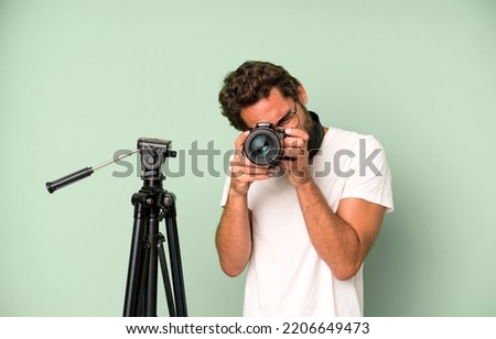 young crazy bearded and expressive man with a photo camera. photographer concept