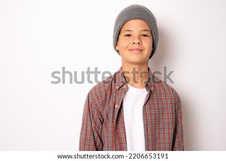 Happy young caucasian boy in casual outfit wearing winter hat isolated over white background Royalty-Free Stock Photo #2206653191