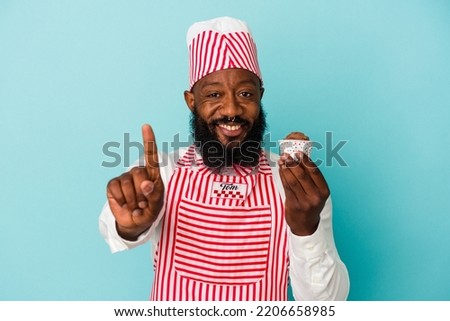 African american ice cream maker man holding an ice cream isolated on blue background showing number one with finger.