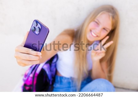Teenage girl taking selfie with mobile phone