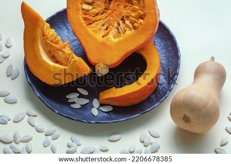 Slices of pumpkin on plate and pumpkin seeds