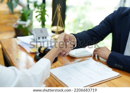 Portrait of a male lawyer shaking hands with a client to settle a court case. Royalty-Free Stock Photo #2206683719
