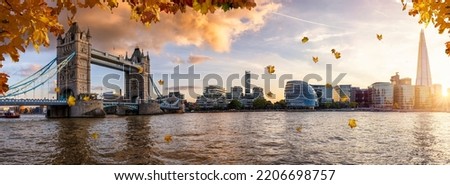 Panoramic view of the London city skyline during beautiful autumn time with golden leaves falling from the trees and warm sunshine colors