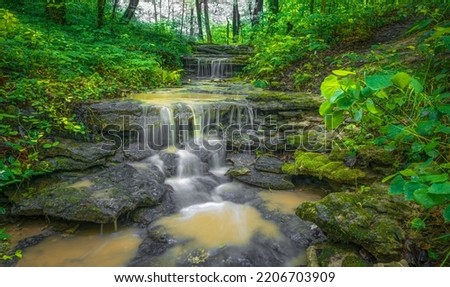 A long exposure waterfall flowing over rocky surface in Cherokee Park, Louisville, Kentucky, United States Royalty-Free Stock Photo #2206703909