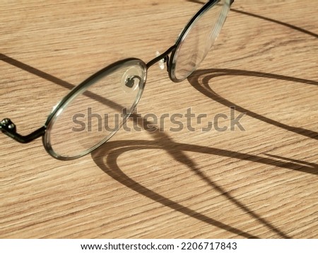 Eyeglasses on  table with shadow