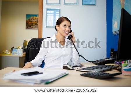 Portrait of young businesswoman talking on phone in office