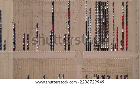 Aerial view of car storage or parking lot new unsold EV cars. Vehicle automaker and manufacturer parking facility. Low carbon footprint EV electric cars are ready for further distribution.  Royalty-Free Stock Photo #2206729949