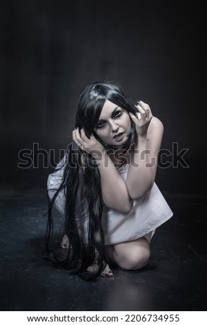 Mystical ghost woman with black long hair on black background