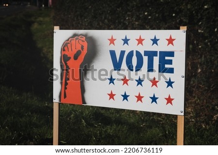 Homemade Voting Sign with Red and Blue Stars and Raised Fist on Side of the Road