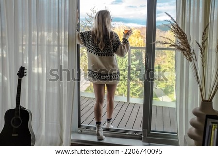 Woman in knitted wool sweater drinks tea a cup, relax at home in autumn day. Health care, authenticity, sense of balance and calmness. Fresh air.