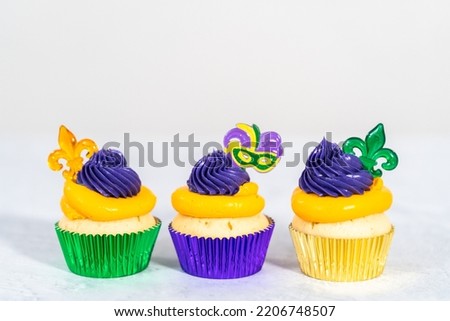 Mardi Gras vanilla cupcakes in foil cupcake cups and decorated with Italian buttercream frosting.