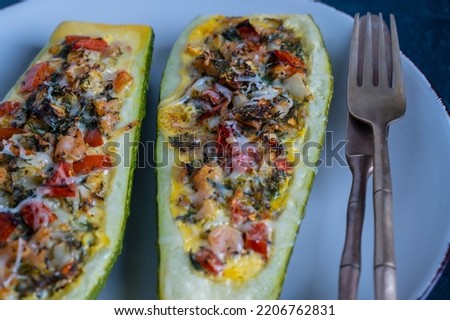 Zucchini stuffed with shrimps, vegetables and cheese. Baked zucchini boats, close up