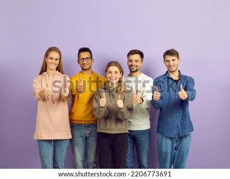 Portrait of smiling multiethnic young people isolated on violet background show thumbs up. Happy diverse multiracial teenagers recommend good training or internship. Recommendation concept. Royalty-Free Stock Photo #2206773691