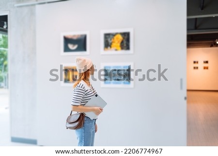 Woman visiting art gallery her looking pictures on wall watching photo frame painting at artwork museum people lifestyle concept. Royalty-Free Stock Photo #2206774967